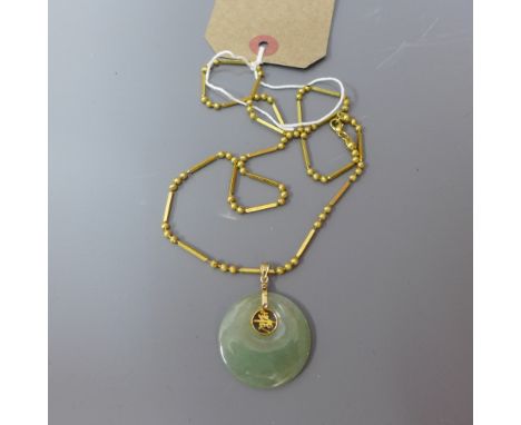 A pi jade disc on a gold plated chain