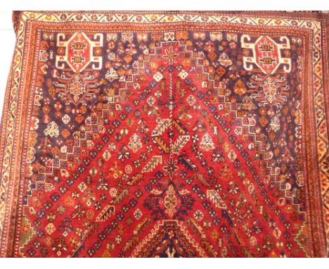 A fine South West Persian Qashgai carpet 263cm x 175cm central diamond medallion with repeating animal and petal motifs on a 