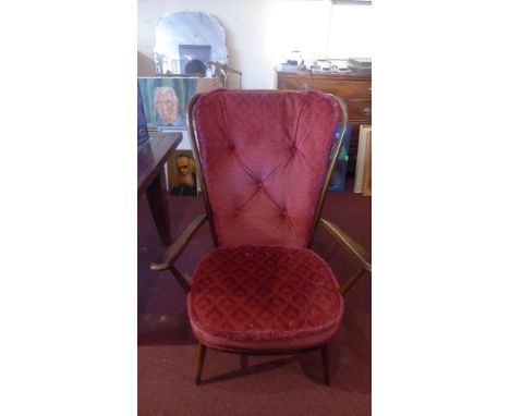 A 1960's Ercol stained beechwood stick back armchair with floral red cushions and raised on circular tapered legs, H 104 x W 