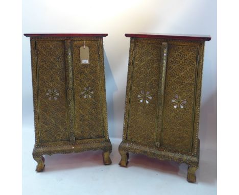 A pair of contemporary clad brass bedside cabinets decorated with stylized swirls raised on carved bracket feet, H 102 x W 59