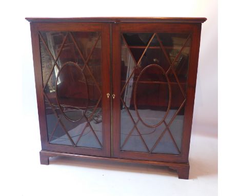 A 19th century mahogany bookcase with two Astragal glazed doors and raised on carved bracket feet, H 116 x W 120 x D 36cm 
