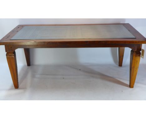 An Indonesian teak dining table, the top made from a carved and pierced door, raised on square tapered legs, H 76 x W 196 x D