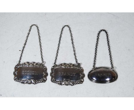 A pair of modern silver decanter collars, for Scotch and Brandy; together with another plated label for Brandy (3)