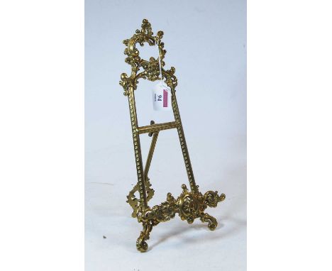 A 19th century miniature brass easel, decorated in the Rococo taste, with C scrolls and rocaille, height 32cm