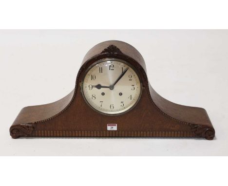 A 1930s oak cased eight day mantel clock, the silvered dial showing Arabic numerals, the case with beaded and scrolled decora