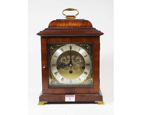 An 18th century style walnut bracket clock, the silvered chapter ring showing Roman numerals, the dial decorated with applied