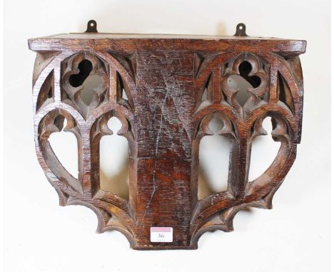 A Victorian carved oak wall bracket, the apron with pierced early English Gothic style carved decoration, width 37cmCondition