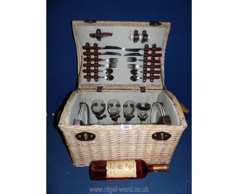 A wicker hamper with contents and wine.