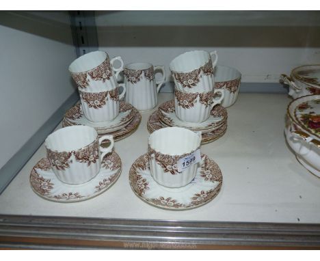 A pretty Teaset of fluted cups, saucers, tea plates, slop bowl and milk jug, with brown floral decoration.