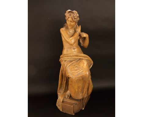 A late 19th century ceramic sculpture of a seated semi-nude female, indistinctly signed, 79cm high