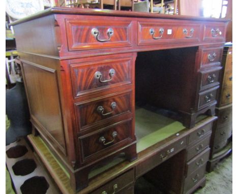 A reproduction Georgian style mahogany kneehole twin pedestal writing desk with inset leather triple panelled top over eight 