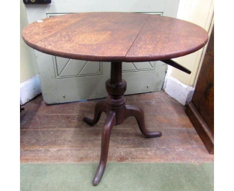 A Georgian oak snap top table raised on a vase shaped pillar and tripod, 76cm diameter