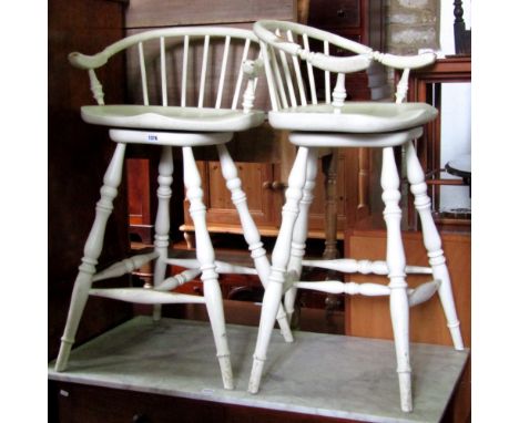 A pair of American style bar seats raised on turned supports and rails, swivel tops with horseshoe shaped rails and stick bac