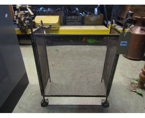 A traditional steel firescreen with folding framework and wire mesh panels
