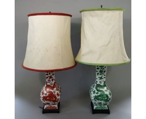 A matched pair of oriental vases, of four sided form, one with green painted writhing dragon, the other with brick red decora