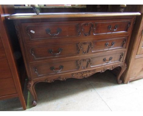 A continental commode fitted with three long drawers with applied mouldings, cast handles on cabriole supports, 1 metre wide