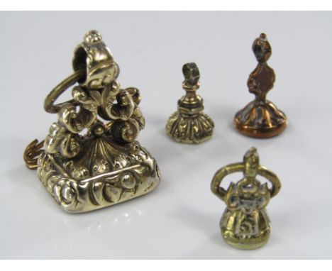 A yellow metal carnelian seal fob with crest and motto 'Vi et copia' together with three miniature examples; two with intagli