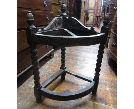 A Victorian carved oak corner stick stand, raised on bobbin supports with carved detail