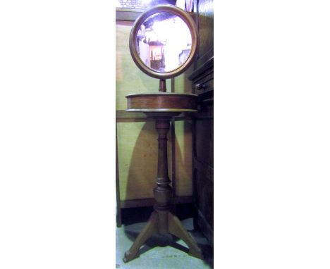 A Victorian oak shaving stand, the circular mirror raised on a platform base with turned column and tripod
