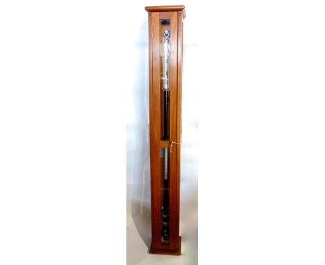 Ships barometer thermometer, upon a black and steel cylinder frame, within a glazed beech cabinet, the cabinet 119cm high