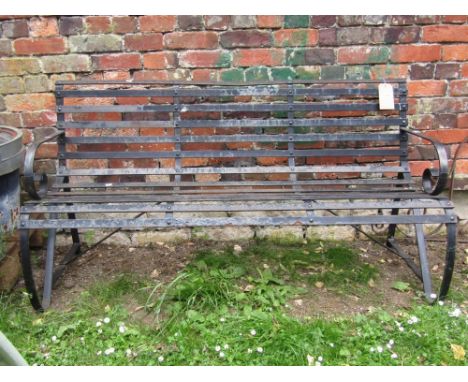 A heavy iron work three seat garden bench, with open strap work seat combined back and scrolled arms, 5ft long approx