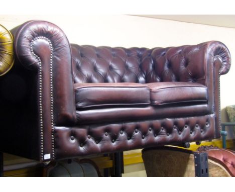 A Victorian style two seat Chesterfield sofa with buttoned framework and faux dark brown leather finish, 170cm wide approx