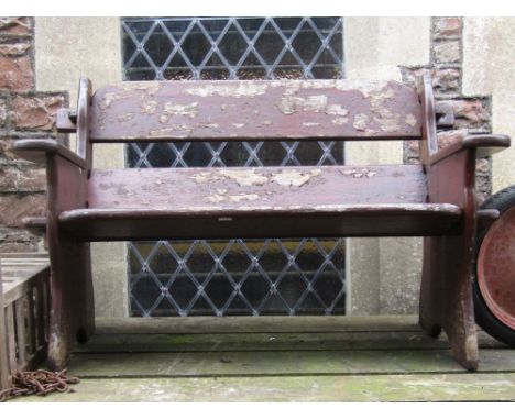 A rustic two seat garden bench with pegged frame and stained finish