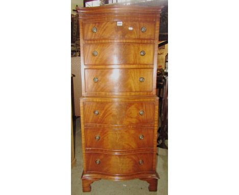 A reproduction Georgian style mahogany chest on chest of serpentine form fitted with six drawers with bracket supports, 55 cm