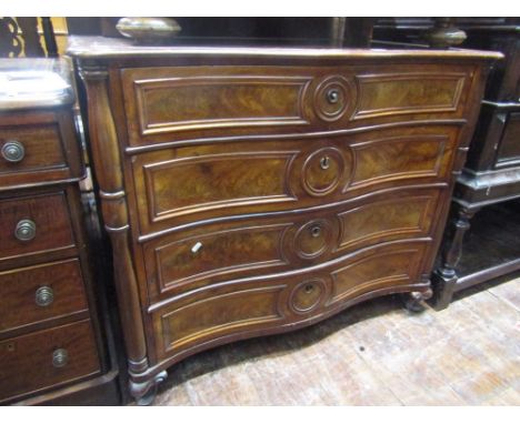 A 19th century continental mahogany commode of serpentine form, enclosing four long drawers, the upper drawer fitted with sli