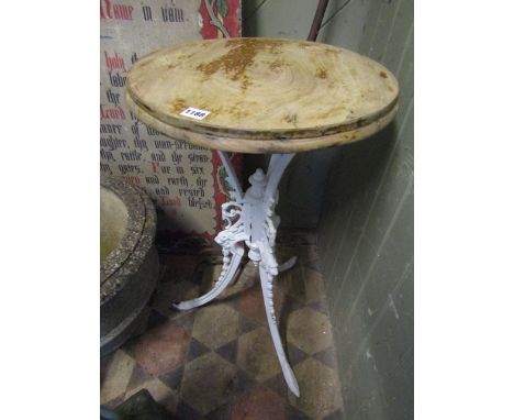 A small cast iron garden/pub table, the decorative cream painted base with swept tripod supports with lions mask scrolling ac