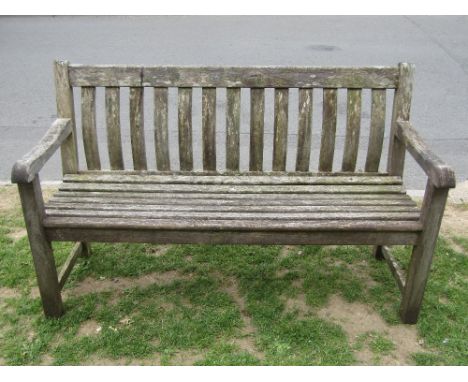 An Alexander Rose Ltd weathered teak three seat garden bench with open slatted seat and curved slatted back