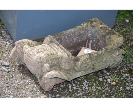 A concrete planter in the form of a model car.