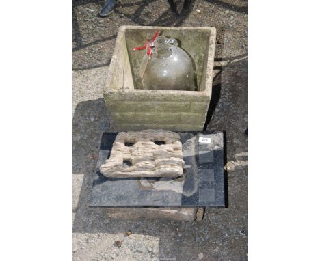 A glass demi-john, planter, slabs, etc.