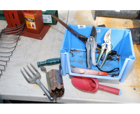 A lin bin of garden tools, forks, bulb planter, dibber etc.