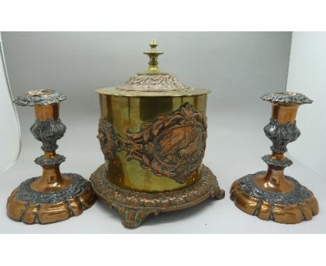 A brass and copper caddy and a pair of candlesticks