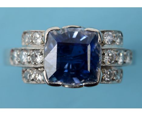 An Art Deco style platinum, sapphire and diamond ring, the natural 4.40ct cushion cut sapphire flanked by ten brilliant cut d