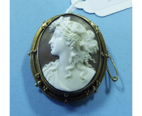 A cameo brooch, carved a portrait of a lady with vines and grapes in her hair, in a yellow coloured metal mount