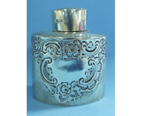 An oval silver tea caddy, initialled, and with embossed decoration, Sheffield 1892, approx. 2.2 ozt, 8.5 cm high