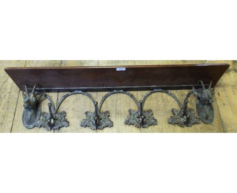 A set of wall hooks, decorated deer, oak leafs and acorns, with a mahogany shelf above, 96 cm wide