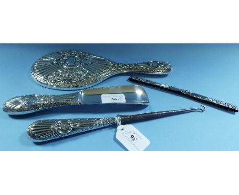 A Victorian silver part dressing table set, monogrammed, comprising a hand mirror, a button hook, a shoe horn, and the silver