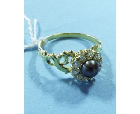 A yellow coloured metal, black pearl and diamond cluster ring