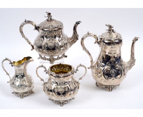 A Victorian silver four piece tea and coffee service, crested and monogrammed within a presentation cartouche, embossed scrol