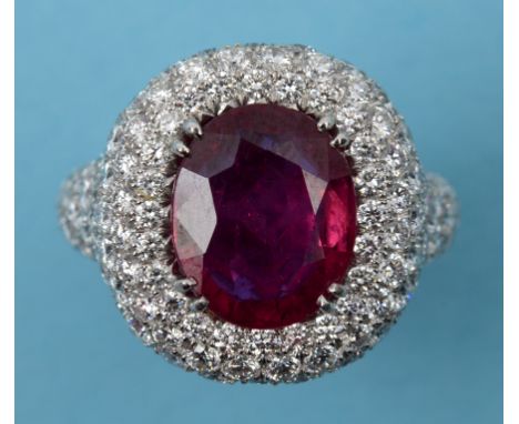 A platinum, ruby and diamond cluster ring, with diamond set shank  See inside front cover colour illustration