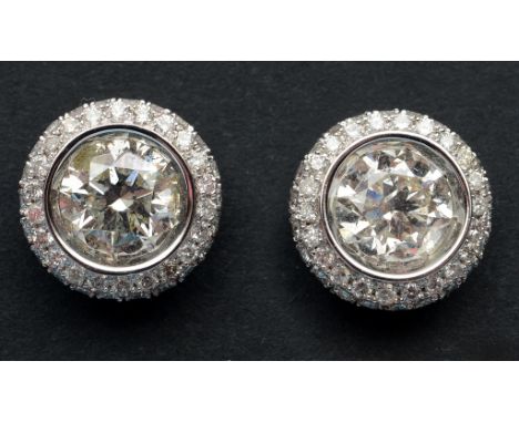 A pair of 18ct white gold and diamond stud earrings, the central brilliant cut stone within a diamond surround  See illustrat