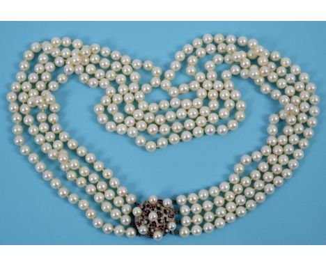 A four strand pearl necklace, the white coloured metal clasp set pearls, rubies and diamonds  See illustration