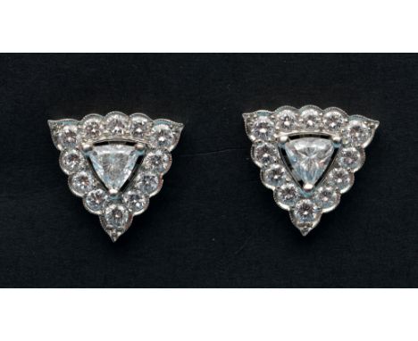 A pair of diamond stud earrings, the central trillion cut stones within a brilliant cut surround  See inside front cover colo