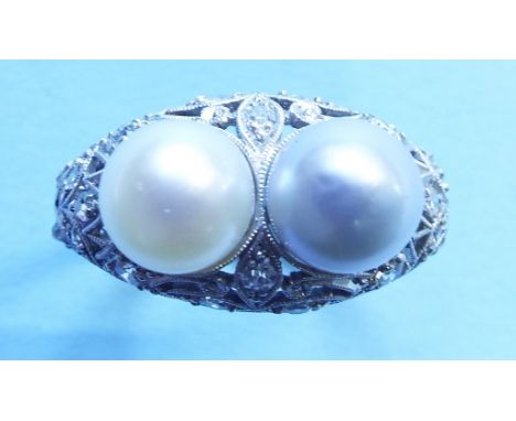 A two pearl ring, in a white coloured metal pierced mount, set diamonds  See illustration 