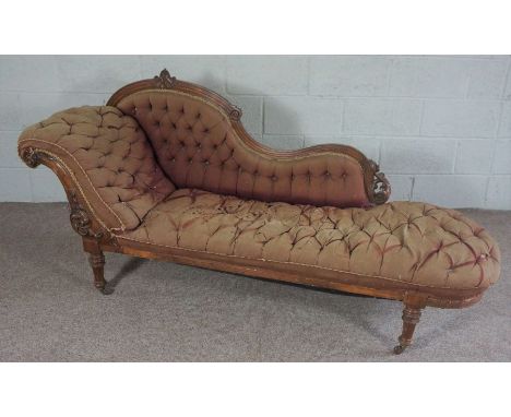 A mid Victorian chaise longue, circa 1870, with a scrolled and button upholstered back, and turned and tapered legs, currentl