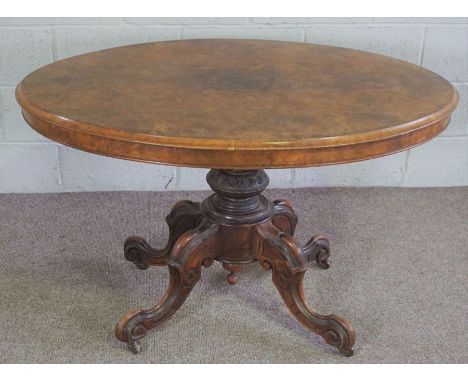 A Victorian walnut oval loo table, mid 19th century, with an hinged top set on a pedestal base with four scrolled legs, 85cm 