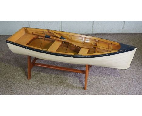 A wooden scale model of a clinker built rowing boat, with painted sides and a pair of oars, 120cm long, 50cm wide (3)